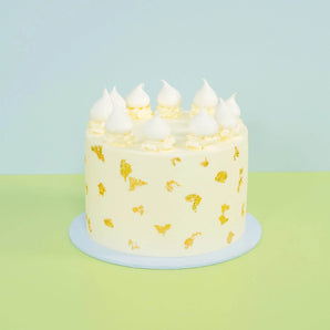 White Gold Wedding Cake with smooth white buttercream, real edible gold leaf, and delicate meringue toppings by Crumbs & Doilies.
